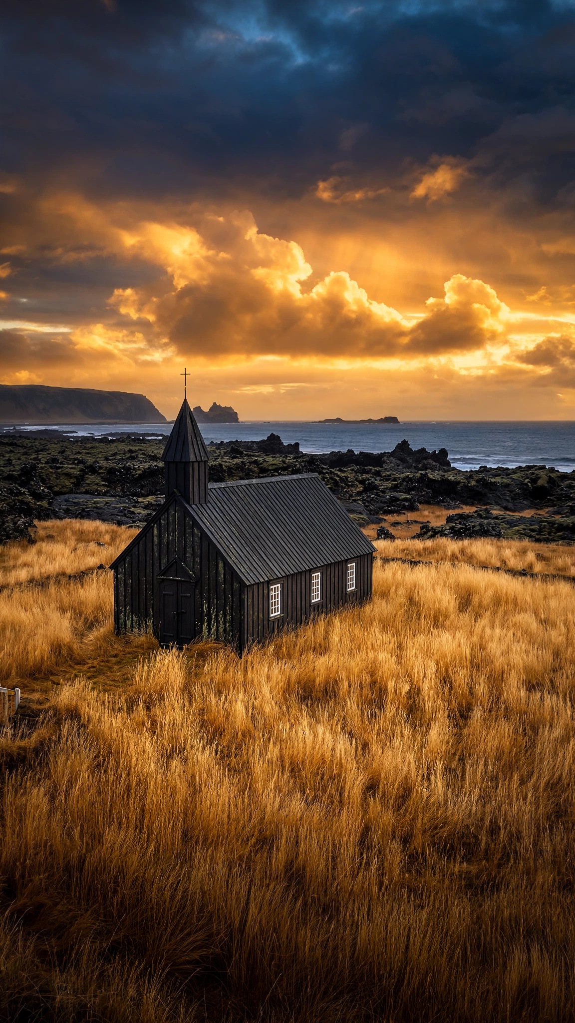 Black Budir church in golden grass at sunset in Iceland