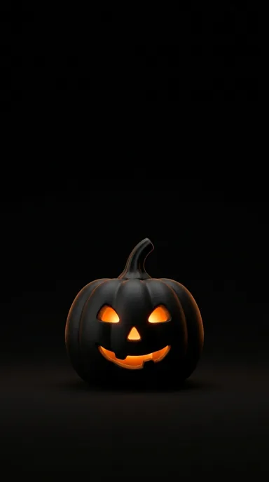 A small black jack-o-lantern has amber eyes and a glowing smile against a nearly black background