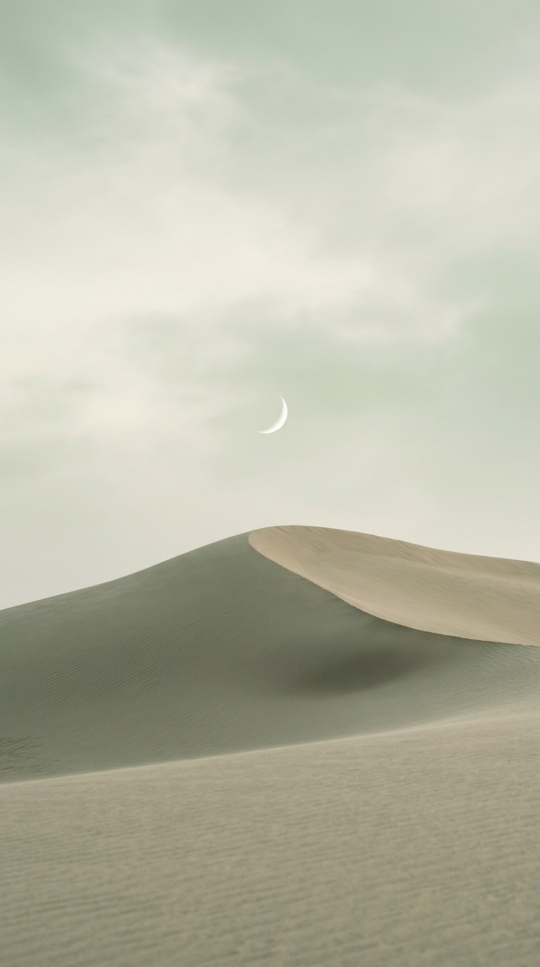 A small crescent above a sand dune.