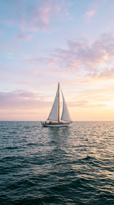 A sailboat beneath a wide pastel sky.