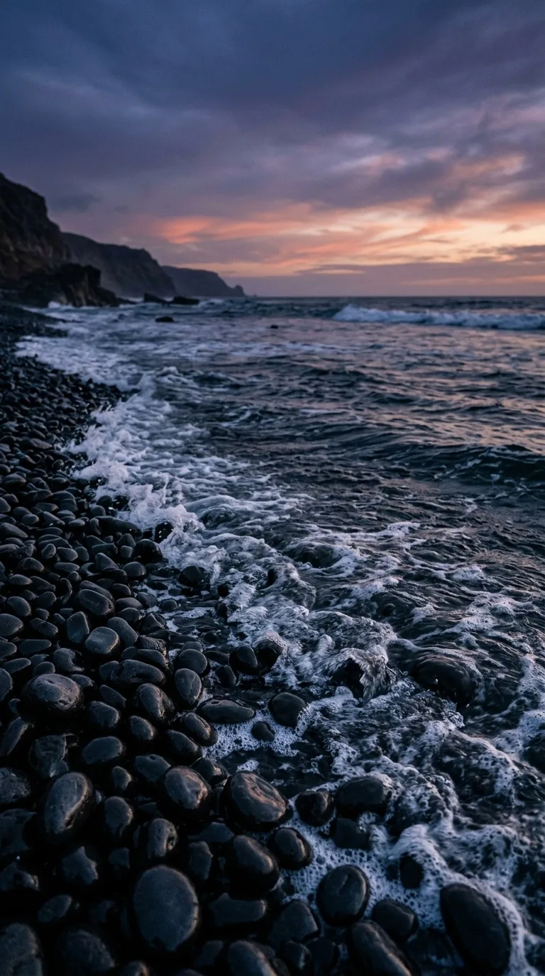 A gentle wave washing over black pebbles.