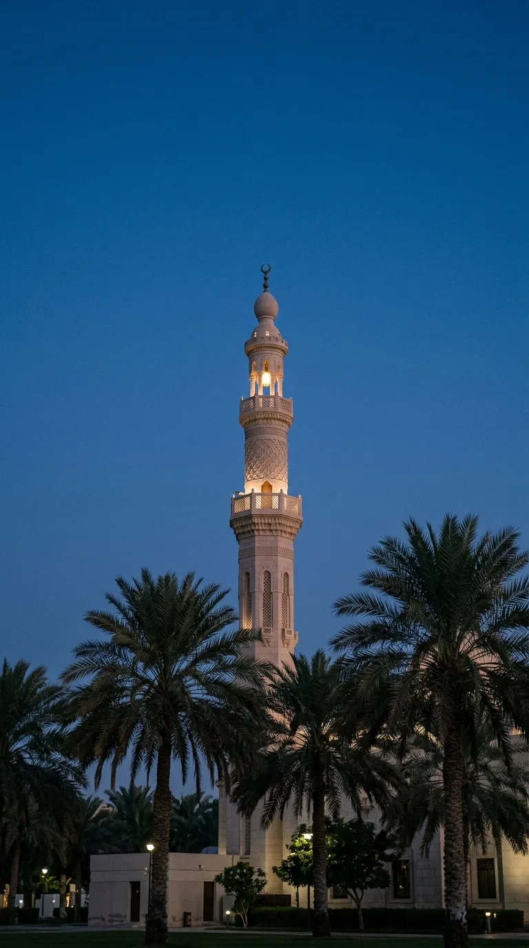 A slender minaret rising above palm trees.
